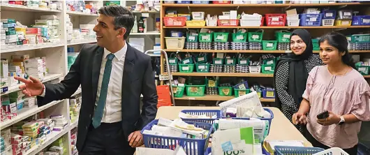  ?? ?? Memory lane: Prime Minister Mr Sunak visits his mother’s former chemist shop – now called Bassett Pharmacy – yesterday