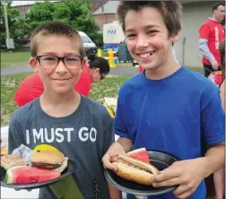  ?? Photo by Ernest A. Brown ?? Cory Krampert, 11, left, and his brother Anthony, 12, are ready to enjoy a hamburger and hot dog, respective­ly, during the City of Woonsocket Summer Lunch Kickoff Thursday at World War II Veterans Memorial Park.