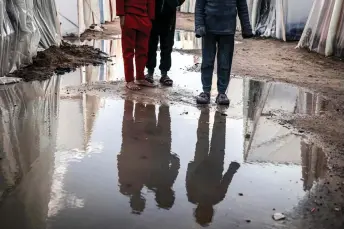  ?? AFP photo ?? Displaced Palestinia­n children stand amid tents flooded by heavy rain, at a makeshift camp in Rafah in the southern Gaza Strip. The UN chief has called on donor states to guarantee the flow of aid to Gaza.—