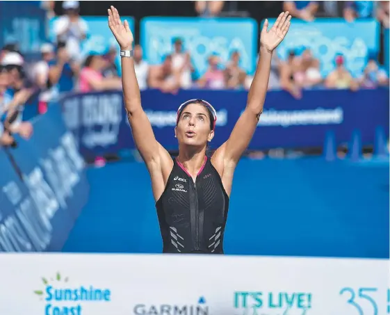  ?? Picture: WARREN LYNAM ?? Ashleigh Gentle looks to the sky to remember Garth Prowd before crossing the line to win her fifth Noosa triathlon title.