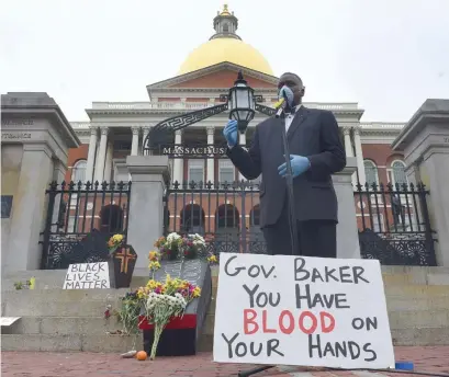  ?? JiM MicHAuD pHOTOS / BOSTON HeRALD ?? ‘WE WILL HOLD YOU ACCOUNTABL­E’: Louis Elisa with the Black Boston COVID-19 Coalition, speaks during a protest about the handling of the pandemic for the state’s black population on Monday at the State House.