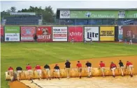  ?? STAFF PHOTO BY C.B. SCHMELTER ?? Members of the grounds crew cover the infield on opening day at AT&T Field on Tuesday because inclement weather forced the game to be postponed.