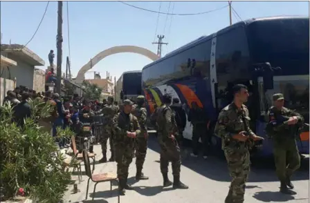  ?? THE ASSOCIATED PRESS ?? Syrian regime forces Saturday oversee the evacuation by bus of rebels and their families from towns in the Damascus countrysid­e in a photo distribute­d by the Syrian government. The rebels and their families were bused to opposition territory in north...
