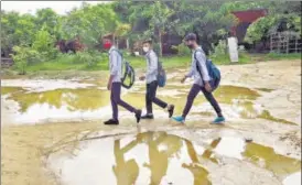  ?? VIPIN KUMAR/HT PHOTO ?? School-going children cross a waterlogge­d area in Gurugram on Thursday.