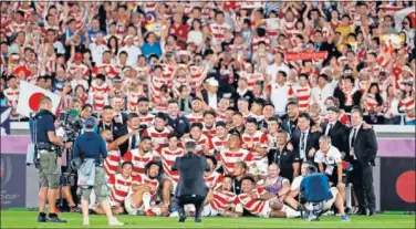  ??  ?? La selección japonesa se fotografía ayer con su afición detrás tras ganar a Escocia en Yokohama.