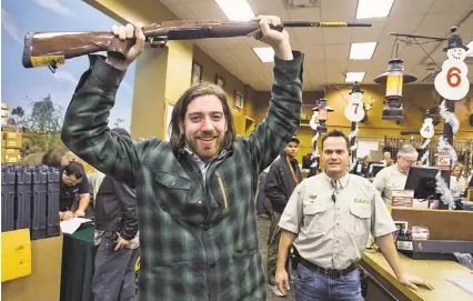  ?? PHOTOS BY TOM TINGLE/THE REPUBLIC ?? Matt Pearson, 20, shows off the Browning X-Bolt Medallion rifle he won as a door prize after entering Cabela’s on Friday morning at 5 a.m. Pearson, who waited about eight hours in line, was one of more than 1,500 shoppers lined up at the store.