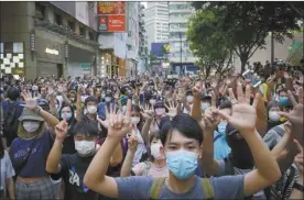  ?? AP file photo ?? Protesters against the new national security law gesture earlier this month with five fingers, signifying the “Five demands — not one less” on the anniversar­y of Hong Kong’s handover to China from Britain in Hong Kong. With hostile rhetoric ratcheting up this week over Beijing’s new national security law on Hong Kong, China has threatened “consequenc­es” after Britain offered refuge to millions in the former colony.