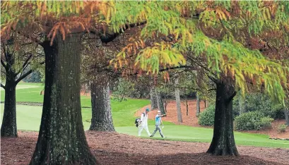  ?? CHARLIE RIEDEL THE ASSOCIATED PRESS ?? Sung Kang walks with his caddie during a practice round for the Masters at the alarmingly silent Augusta National Golf Club.