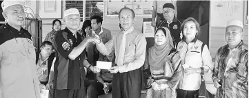  ??  ?? Tiong presents the donation to Ismail (second left) as SMC deputy chairperso­n Rogayah Jemain (third right), Loh (second right) and others look on.