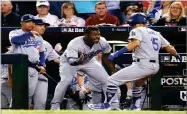  ??  ?? AP PHOTO BY RICK SCUTERI Los Angeles Dodgers’ Austin Barnes (15) celebrates with Yasiel Puig in the dugout after hitting a solo home run during the sixth inning of game 3 of baseball’s National League Division Series against the Arizona Diamondbac­ks,...