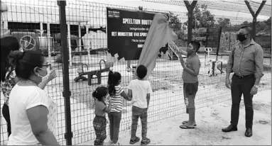  ??  ?? Het naambord van de speeltuin van sportveren­iging Houttuin wordt onthuld terwijl een paar kinderen toekijken.
(Foto: SV Houttuin)