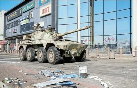  ?? /ROGAN WARD/REUTERS ?? A military tank patrols near a shopping centre which was damaged after several days of looting following the imprisonme­nt of former president Jacob Zuma.