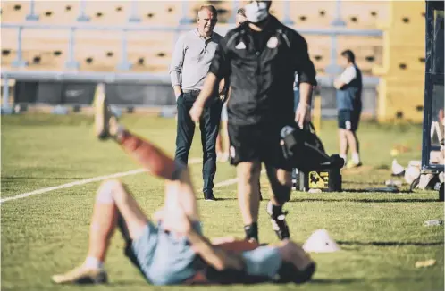  ??  ?? INJURED: Matty Stenson after picking up his hamstring injury in pre-season, with physio Aaron Scholes and Town boss Pete Wild looking on.