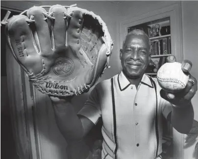  ?? THE COMMERCIAL APPEAL ?? Negro League Hall of Famer Joe Scott displays a big smile and a “Joe Scott” model glove by Wilson on July 9, 1983.