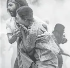  ?? PROVIDED BY NETFLIX ?? Jerry Rubin ( Jeremy Strong) helps a protester to safety in “The Trial of the Chicago 7.”