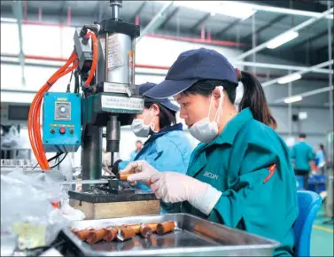  ?? XINHUA ?? Employees produce electronic aluminium foil products at a factory in Hezhou, the Guangxi Zhuang autonomous region.