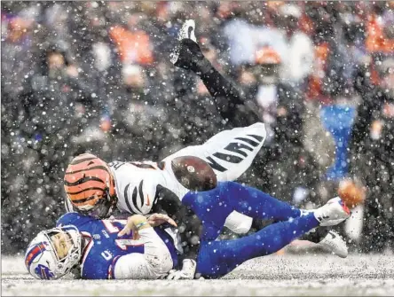  ?? JOSEPH OSSAI Adrian Kraus Associated Press ?? of the Bengals pounces on Bills quarterbac­k Josh Allen, who had a rough outing in another disappoint­ing playoff defeat.