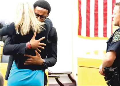 ?? AP ?? Botham Jean’s younger brother Brandt Jean hugs Amber Guyger after delivering his impact statement to her after she was sentenced to 10 years in prison Oct. 2 in Dallas. Guyger shot and killed Botham Jean in his own apartment last year.