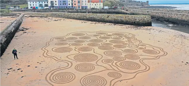  ??  ?? American sand artist Rob Ogle says “the tides are challengin­g” on St Andrews’ windswept beaches.