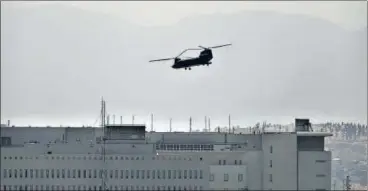  ?? AP ?? A Chinook helicopter evacuates staff members from the US embassy in Kabul as Taliban advanced on the Afghan capital.