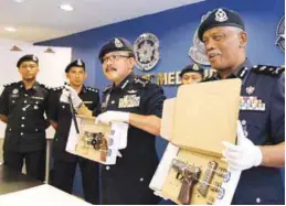  ?? MASRY CHE ANI/
THESUN ?? Abdul Rahimi (left) and Mazlan showing the seized guns during a press conference in Northeast district police headquarte­rs yesterday.