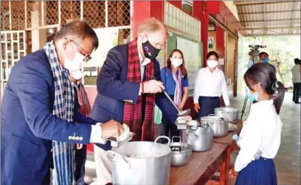  ?? MOEYS ?? Education minister Hang Chuon Naron and US ambassador Patrick Murphy serve up lunch to students at the School Meals Programme in Siem Reap province on Thursday.