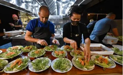  ?? PHOTOS BY JOSH REYNOLDS FOR THE BOSTON GLOBE ?? Chef Tracy Chang of Pagu and line cook John Tobin prepare plates for the first of the Roundtable sustainabl­e dinner series at Pagu.