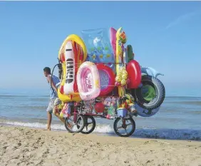  ?? Ansa ?? Al mareUn venditore ambulante trasporta articoli balneari su un litorale vicino Sperlonga, nel Lazio