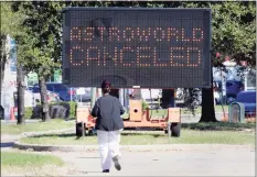  ?? Michael Wyke / Associated Press ?? A pedestrian crosses Main Street in front of a sign announcing the cancellati­on of Astroworld on Saturday in Houston.