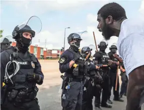  ?? PHOTOS BY MATT STONE/USA TODAY NETWORK ?? A protester asks a Louisville Metro Police Department officer to look him in the eyes during a protest for Breonna Taylor in Louisville, Ky. About 60 people were arrested during that day’s protests.