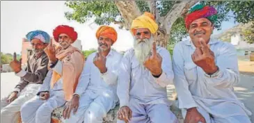  ?? AP PHOTO ?? Men show the indelible ink mark on their index fingers after casting their vote in village Padampura near Ajmer on Friday.