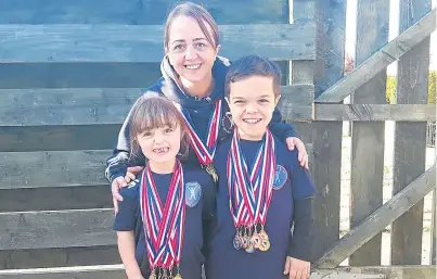  ??  ?? Skye and Finlay Davidson with mum Hailey, from Inverkeith­ing, and their impressive medal haul.