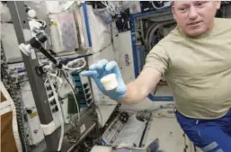  ??  ?? Internatio­nal Space Station astronaut Barry “Butch” Wilmore holds a science sample container that took two hours to make in December 2014. The container was the first object to be printed with two parts: a lid and a container.