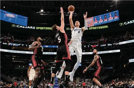  ?? Nick Wass/Associated Press ?? Wizards center Kristaps Porzingis had 20 points and a season-high 17 rebounds in Washington’s win over the undermanne­d Heat.