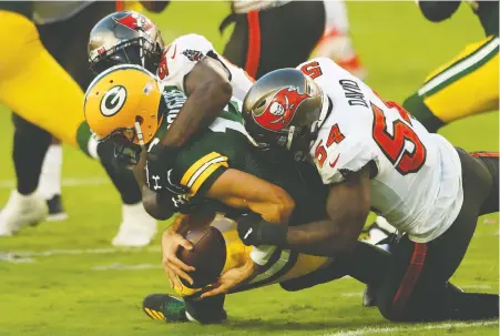  ?? MIKE EHRMANN/ GETTY IMAGES ?? Jason Pierre-Paul, top, and Lavonte David of the Tampa Bay Buccaneers sack Green Bay QB Aaron Rodgers during Sunday's game in Tampa. It was a rough day for Rodgers who was watching from the sidelines by the end.