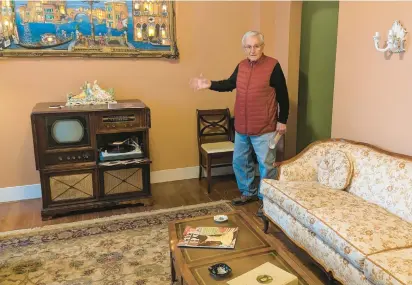  ?? JANICE NEUMANN/DAILY SOUTHTOWN PHOTOS ?? Bielenberg Historic Pullman House Foundation volunteer Mike Shymanski shows visitors the living room of Americo “Leno” Lisciotto’s former home in the Pullman neighborho­od. It has been restored to look like it did in the 1960s, when Lisciotto led an effort that helped save Pullman from redevelopm­ent.
