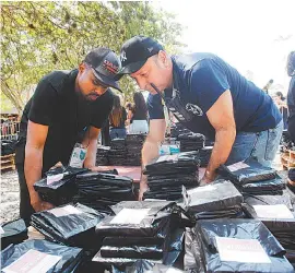  ?? ESTEFAN RADOVICZ ?? Livros com temática LGBT enviados por Felipe Neto chegam à Bienal, cobertos por plástico preto. No alto, à direita, Luana Gomes e Wellington Pessanha com o exemplar