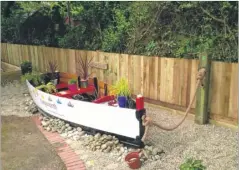  ??  ?? The boat and wooden cross in the school’s new garden