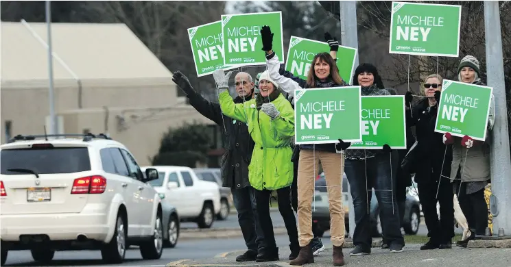  ?? — PHOTOS: THE CANADIAN PRESS ?? Supporters of Green party candidate Michele Ney, centre, wave signs to rally support for their candidate on Wednesday in Nanaimo.