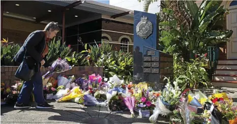  ?? PHOTO: KEVIN FARMER ?? GROUNDSWEL­L OF SUPPORT: Flowers in tribute to Senior Constable Brett Forte left under the Toowoomba police memorial outside Southern Region District headquarte­rs in Neil St yesterday.