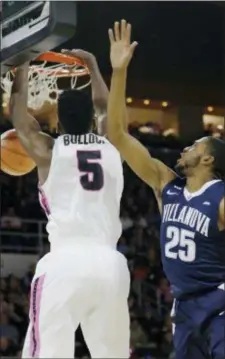  ?? STEPHAN SAVOLA — THE ASSOCIATED PRESS ?? Providence forward Rodney Bullock, left, dunks over Villanova’s Mikal Bridges Wednesday. Bullock and the Friars claimed a 76-71 win Wednesday night.