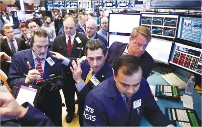  ?? (Brendan McDermid/Reuters) ?? TRADERS WORK on the floor of the New York Stock Exchange yesterday. Gains in the energy sector, up more than 1%, kept the S&P 500 afloat. None of the other 10 sectors moved more than a half a percent up or down.