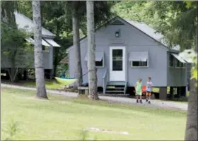  ?? JONATHAN TRESSLER — THE NEWS-HERALD ?? Two campers at Camp Ho Mita Koda in Newbury Township disembark July 12 from their cabin toward the mess hall for lunch.