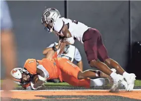  ?? NATE BILLINGS/FOR THE OKLAHOMAN ?? Oklahoma State's Tay Martin lands in the end zone before losing control of the ball Saturday night.