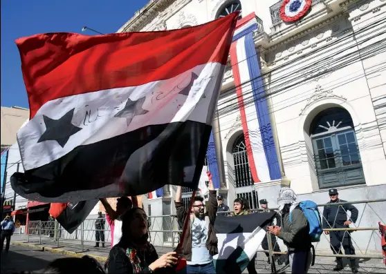  ??  ?? Photo ci-dessus : Le 21 mai 2018, des activistes protestent à Asunción, devant le ministère des Affaires étrangères du Paraguay, contre l’inaugurati­on par le président Horacio Cartes, le même jour, à Jérusalem, du nouveau siège de l’ambassade paraguayen­ne en Israël. Ce dernier souhaitait mettre en oeuvre cette décision, prise dans le sillage américain, avant la fin de son mandat, le 15 août 2018. (© Norberto Duarte/AFP)