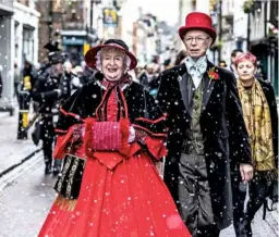  ??  ?? Norman Munn, dressed as Charles Dickens, followed by the Seven Poor Travellers (above). A couple dressed in matching Victorian Sunday best enjoy the admiring glances of onlookers (left).