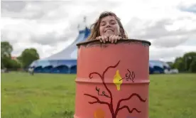  ?? ?? Bethany Stenning, a bin painter who will perform with Ishmael Ensemble at West Holts stage on Sunday morning, peeks out from inside a bin. Photograph: Chris Humphrey/The Guardian