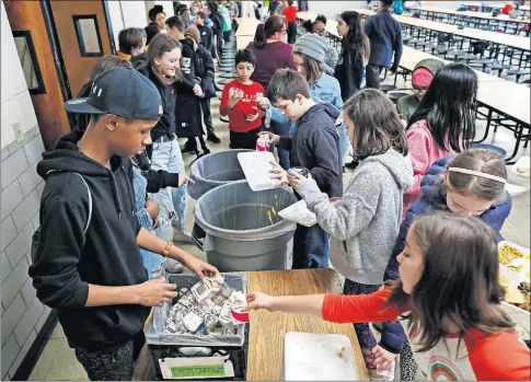  ?? [ADAM CAIRNS/ DISPATCH] ?? Eighthgrad­er Jaevonte Allen, lower left, helps collect milk cartons as fifth- and sixth-grade students sort their food waste and trash at the end of lunchtime as part of the recycling and composting project at Columbus Gifted Academy in the Short North.