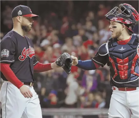  ?? AP PHOTO ?? STARTS WITH ONE: Corey Kluber gets congratula­tions from catcher Roberto Perez during last night’s Game 1 of the World Series in Cleveland. Kluber pitched shutout ball into the seventh inning and Perez belted a pair of home runs as the Indians rolled...