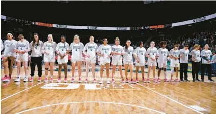  ?? AL GOLDIS/AP ?? Michigan State women’s basketball players and staff stand together before a game against Maryland on Saturday in East Lansing, Michigan. The Spartans held a moment of silence less than a week after three students were killed in a shooting on campus.